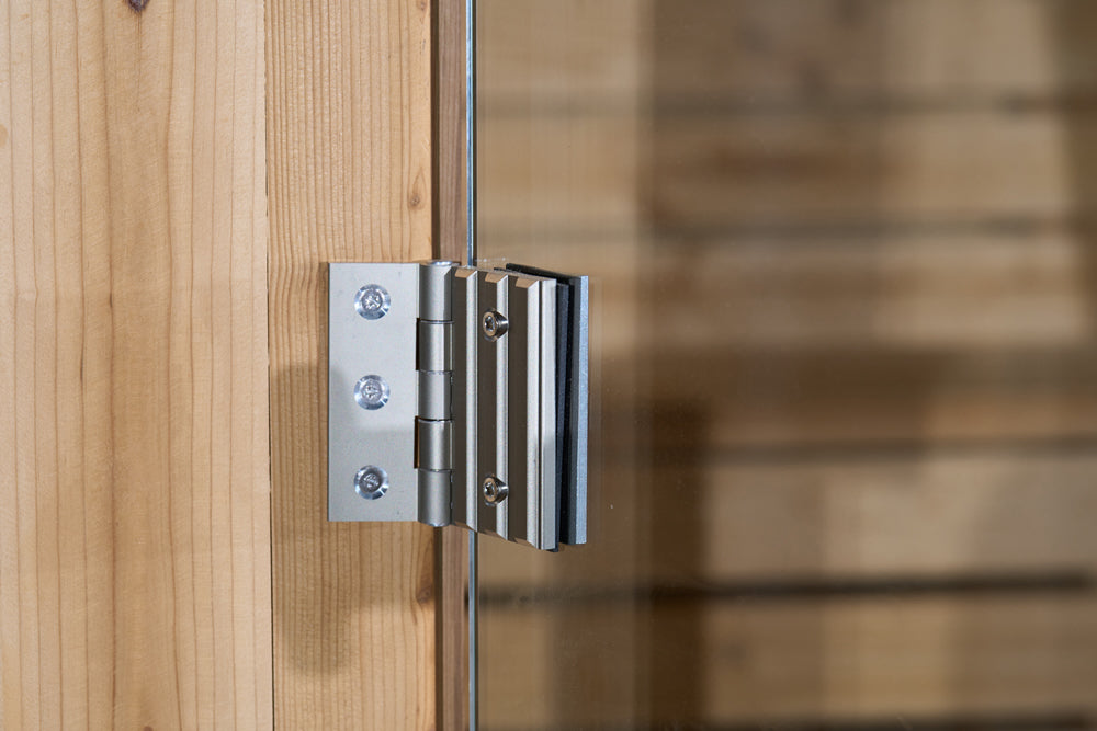 Metallic door hinge on a wooden door with a blurred background