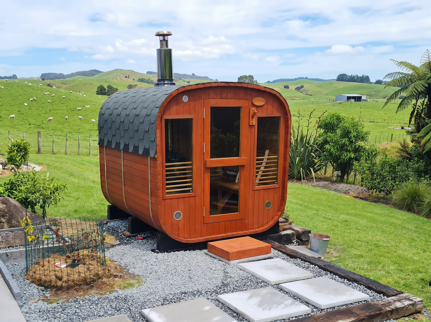 Wooden shepherd's hut in a rural setting with green fields and hills in the background.
